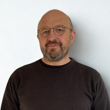 Porträt von Andreas Nitsch vor weißer Wand